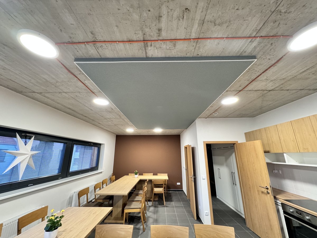 Moderní kancelářský prostor s geometrickým napínaným stropem, integrovaným osvětlením LED a akustickým panelem.